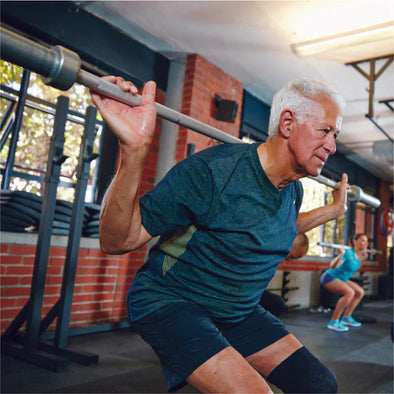 An elderly man doing a squat