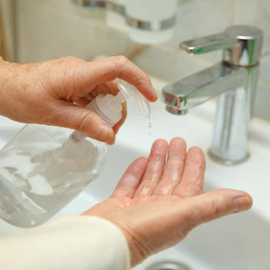 A person putting soap on their hands in front of a sink