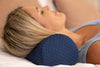 A woman laying down with a roll pillow under her neck