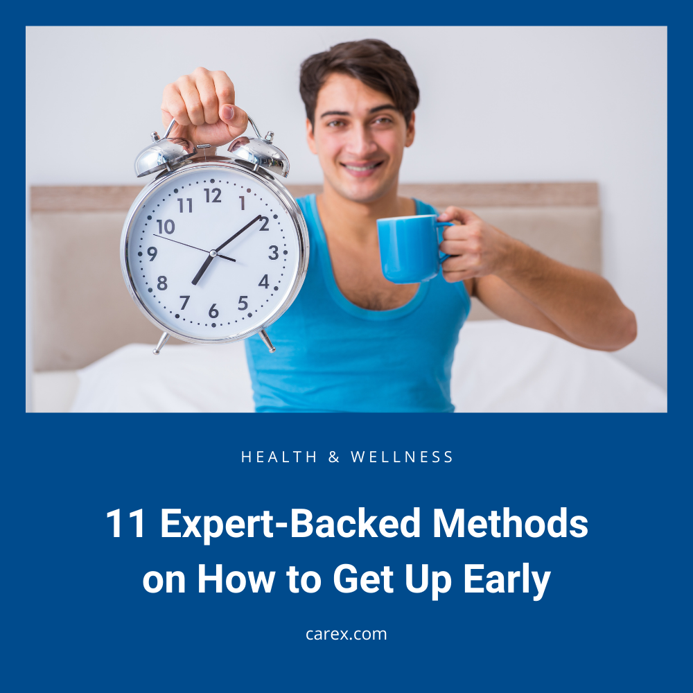 Smiling man holds an alarm clock and coffee mug, illustrating the best way to get up early