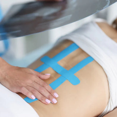 A woman lying down with kinesiology tape on her back