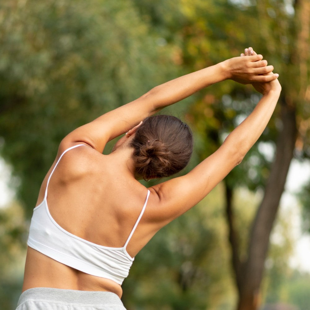 A woman lifting her arms stretching her upper back