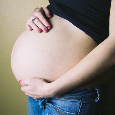 A pregnant woman holding her stomach