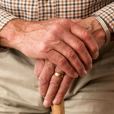 An elderly man holding his wrist