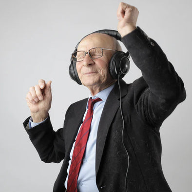 An elderly man dancing and listening to music