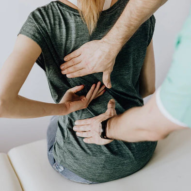 A physical therapist pressing on a patient's back