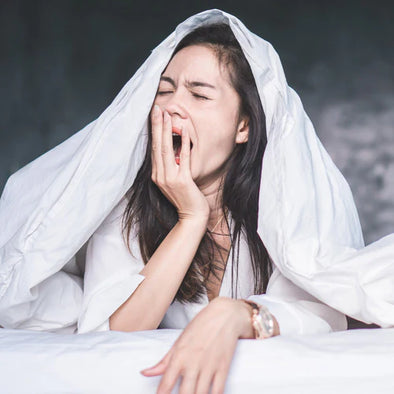 A woman in bed yawning