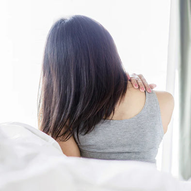 A woman waking up with back pain