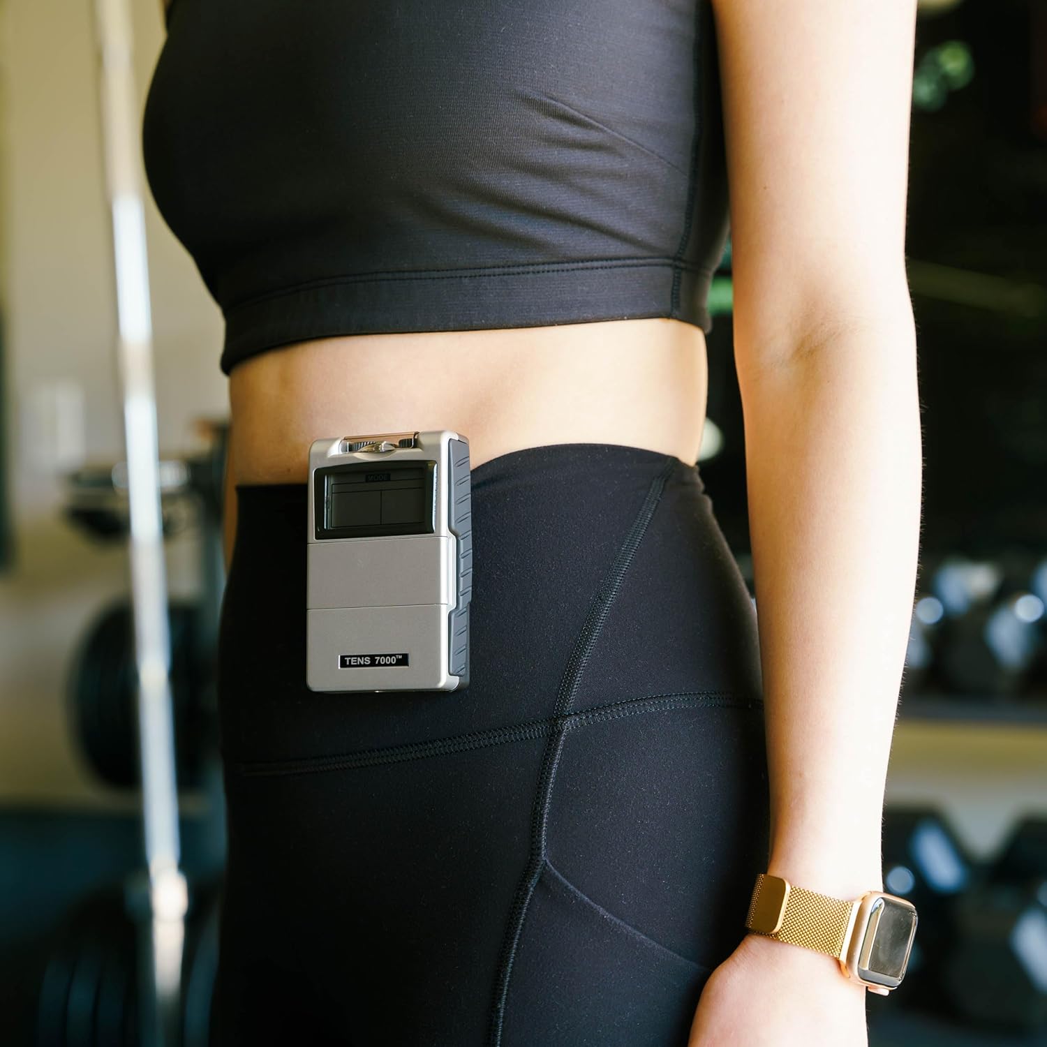 A TENS unit clipped to a woman's pants