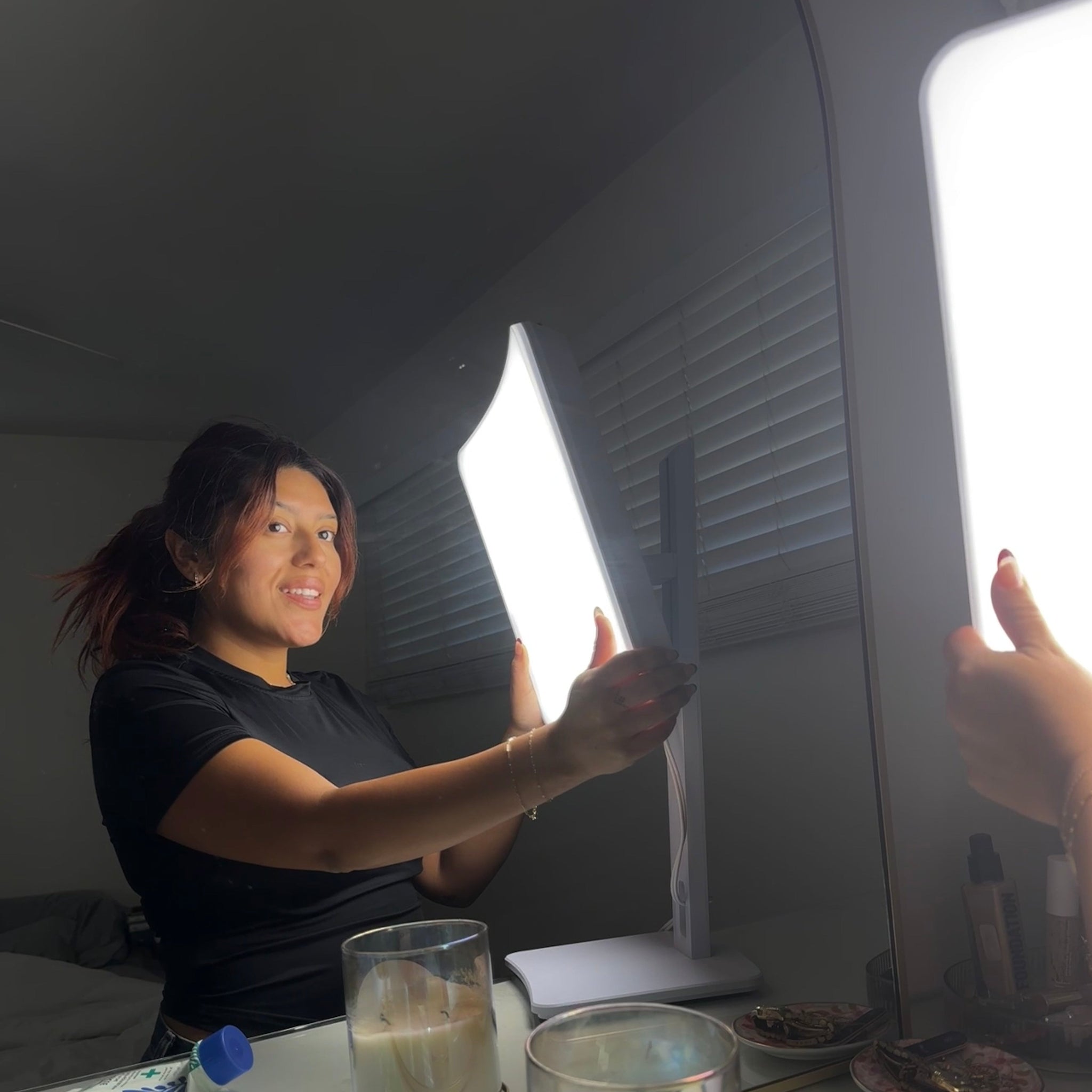 A woman adjusting the  Day-Light Elite Light Therapy Lamp