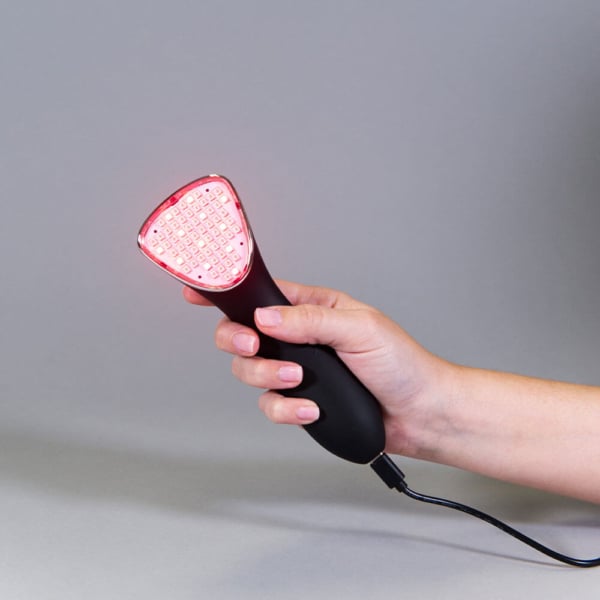Red light therapy for pain device being held
