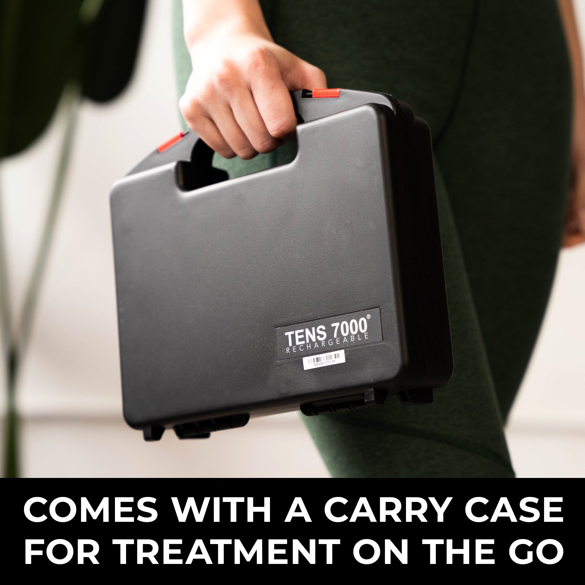 Person holding a TENS 7000 device with a carry case, indicating portability.