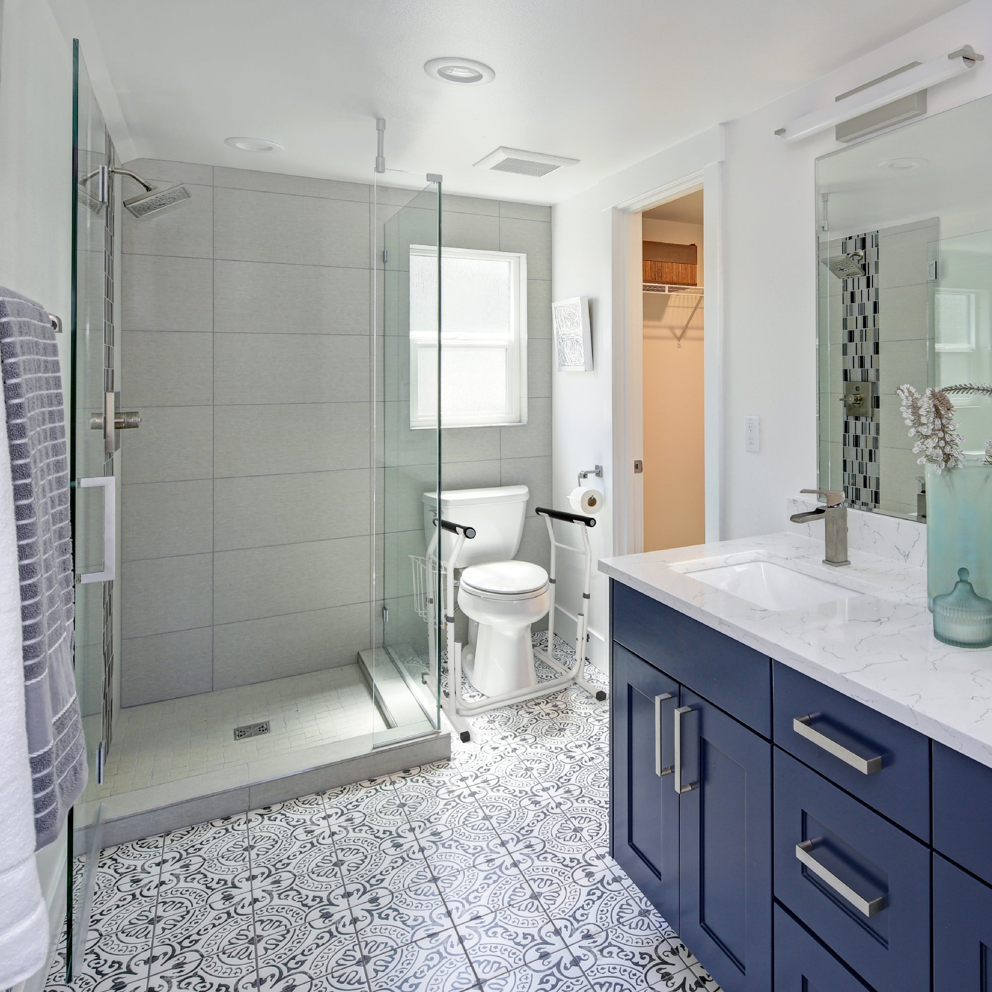 A white toilet safety frame in front of a toilet in a bathroom